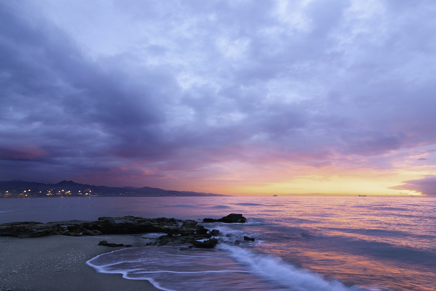 Rosa und orangefarbenes Licht über dem Meer bei Sonnenuntergang
