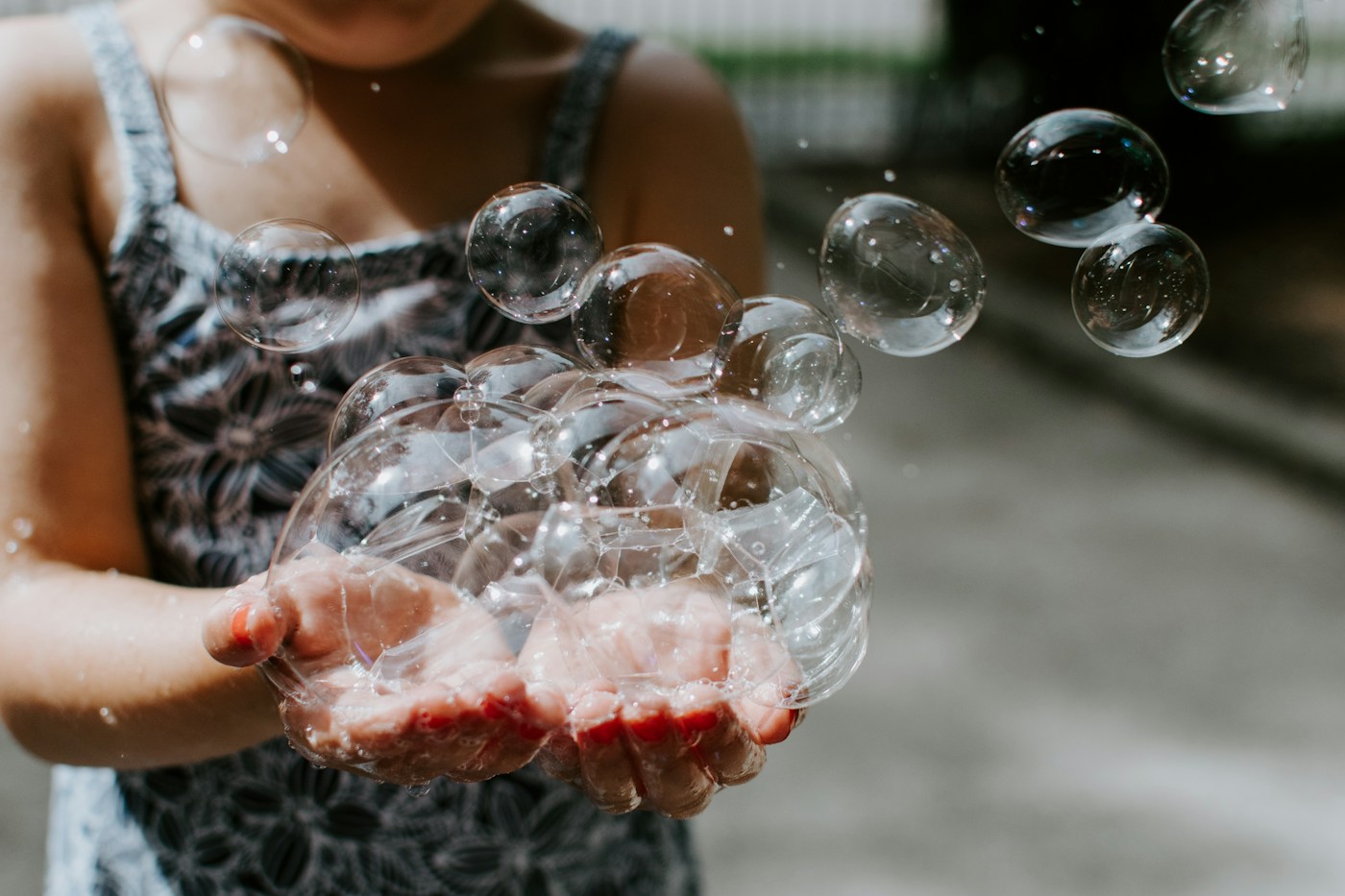 Soap bubbles floating above open hands